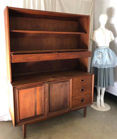 an old wooden dresser next to a mannequin