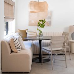 a living room filled with furniture and a round table in front of a painting on the wall