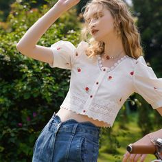 A short top embroidered with bright red rose petals. The collar and hem are decorated with lace embroidery. The bright red ruby buttons are also cute. We recommend pairing it with high-waisted denim. 
 
 
 Size 
 
 S size 
 
 Length: 41cm 
 Shoulder width: 32cm 
 Bust: 86cm 
 Waist: 78cm 
 Sleeve length: 28cm 
 
 
 M size 
 
 Length: 42cm 
 Shoulder width: 33cm 
 Bust: 90cm 
 Waist: 82cm 
 Sleeve length: 29cm 
 
 
 L size 
 
 Length: 43cm 
 Shoulder width: 34cm 
 Bust: 94cm 
 Waist: 86cm 
 Sleev Summer Cropped Tops With Lace Collar, Cropped Tops With Lace Collar For Summer, Cute Fitted Blouse With Floral Embroidery, Spring Cropped Blouse With Lace Collar, Cropped Floral Embroidered Blouse, Cute Red Tops With Floral Embroidery, Rose Flower Embroidery, Short Blouse, Cottagecore Clothes