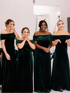 the bridesmaids pose in their green dresses for a wedding photo with one woman covering her mouth