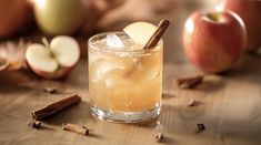 an apple cider with cinnamon sticks and apples in the background