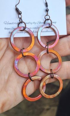 These rustic, boho style earrings feature 3 copper hoops 1" in diameter that have been fire painted using a propane torch to bring out the different colors in the metal when heated. NOTE:  Certain lighting will bring the colors out more than other types of lighting. These earrings measure just under 4" in length.  They will ship in a gift box or bag via USPS with tracking info provided. Artsy Nickel-free Copper Earrings, Unique Hand Painted Copper Jewelry, Multicolor Round Copper Jewelry, Unique Hand-painted Copper Jewelry, Adjustable Nickel-free Rust-colored Jewelry, Nickel-free Copper Artsy Jewelry, Nickel-free Rust-colored Metal Jewelry, Adjustable Rust-colored Nickel-free Jewelry, Small Bohemian Copper Hoop Earrings