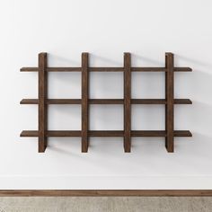 a wooden shelf on the wall in an empty room with white walls and flooring