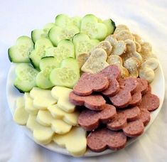 a white plate topped with cucumbers and sausage