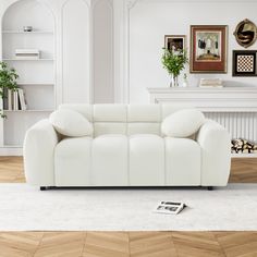 a white couch sitting on top of a hard wood floor