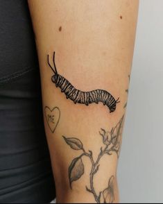 a black and white photo of a butterfly caterpillar tattoo on the right arm