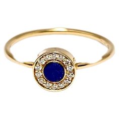 A modern ring design with a nod to the geometric style of the 1970s This ring is made of 18 kt yellow gold. The central part mounts a round-cut Lapis lazuli. the stone is surrounded by a frame of Diamonds weighing 0.07 carat. The weight of the gold is 1.95 grams. The mark of the gold and the manufacturing company are shown on the inside of the band. The size of this ring is 13 ( 6.75 US ) and is available in any size. This model is also available with Turquoise, Malachite and Coral. Matching earrings are also available. This jewelry is new and is shipped with certificate of authenticity and box. It is shipped from our store, which has experience in selling antique and contemporary jewelry and watches since 1938. Modern Gold Ring With Round Stone, Modern Gold Rings With Round Stone, Modern Yellow Gold Ring With Round Stone, Modern 14k Gold Ring With Halo Setting, Modern 14k Gold Round Sapphire Ring, Modern Blue Round Diamond Ring, Modern Ring Design, Lapis Lazuli Jewelry, Selling Antiques