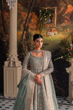 a woman in a blue and silver lehenga is standing on a tiled floor