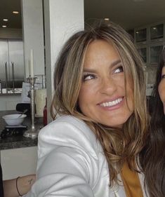 two women are taking a selfie in the kitchen