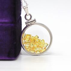 "Vibrant handcrafted brand new sterling silver genuine yellow sapphire shaker locket! This radiant pendant is dime sized with coin style bezels, and clear lucite covers. The round charm showcases genuine fancy sapphires in bright yellow hues. There is an estimated 2.5 CTW of faceted baguette cut sapphires sparkling within the double sided locket's clear lucite covers. A gorgeous piece of brand new gemstone jewelry, featuring beautiful genuine gems! ERA - New METAL / MATERIAL - Sterling silver lo Yellow Polished Jewelry As A Gift, Yellow Jewelry With Polished Finish For Gifts, Citrine Round Jewelry As A Gift, Oval Yellow Jewelry As Gift, Citrine Jewelry With Polished Finish As Gift, Citrine Jewelry With Polished Finish For Gift, Amber Locket Jewelry As A Gift, White Gold Yellow Sapphire Jewelry Gift, Yellow Round Jewelry As Gift