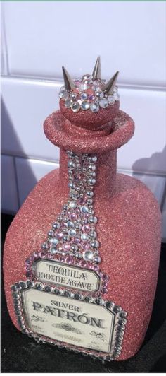 a pink bottle with a crown on top