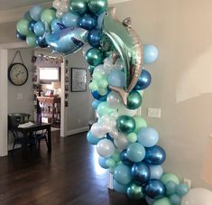 the balloon arch is decorated with blue, green and silver balloons in an elegant manner