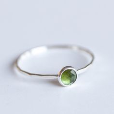 Tiny skinny stackable ring with beautiful moss green tourmaline stone. It is made with a skinny but sturdy band, which allows you creating mind-blowing stacking sets! The ring is ideal for everyday wear and it will also look amazing with a festive dress.The ring is 0,8-0,9 mm thick and looks very dainty on the finger. Choose the size of the stone (3 or 5 mm), stone finish (smooth cabochon or rose cut) and material for the ring (sterling silver or 9k gold).If you want to change the ring band desi Green Sterling Silver Stackable Emerald Ring, Green Sterling Silver Stackable Rings For May Birthstone, Everyday Green Gemstone Stackable Rings, Everyday Green Stackable Rings, Green Stackable Rings For Everyday, Everyday Green Stackable Rings With Bezel Setting, Minimalist Green Sterling Silver Birthstone Ring, Minimalist Green Birthstone Ring In Sterling Silver, Green Minimalist Stackable Rings With Bezel Setting