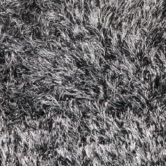 an area rug that looks like it is covered in grey and white shaggy yarns