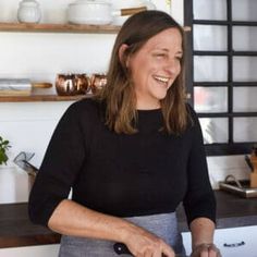 a woman is smiling while holding a knife