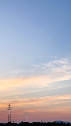 an airplane is flying high in the sky at sunset with power lines and telephone poles