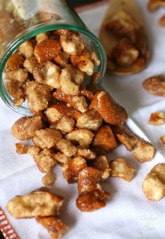 a pile of walnuts sitting on top of a white cloth next to a bottle