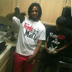 two young men standing in a kitchen next to each other