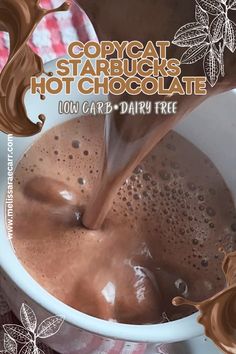 a close up of a cup of hot chocolate with milk being poured into the mug