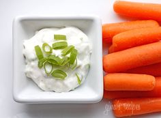 carrots, celery and sour cream in a bowl on a white surface