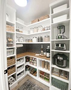 an organized pantry with white shelving and baskets