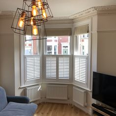 a living room filled with furniture and a flat screen tv on top of a hard wood floor