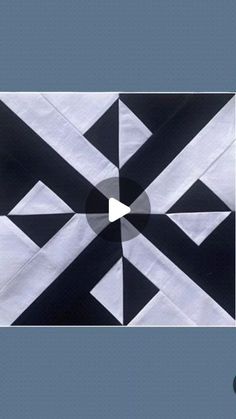 a black and white quilt with an arrow in the center that is cut into squares