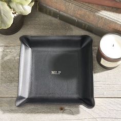 a personalized black leather tray next to a candle