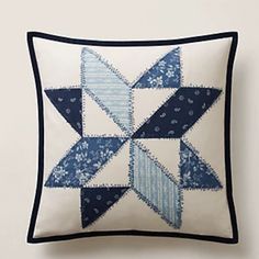 a blue and white patchwork pillow on a wall