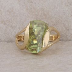 This ladies 14k yellow gold ring has a fantasy cut sphene that has a light green color to it. There are small nicks on the facet edge but that does not effect the integrity of the ring. It measures 14 mm in height and 10.75 mm in length. The ring weighs 5.5 grams and the finger size is 6.5. Condition: Pre-Owned *All items are thoroughly inspected for quality assurance purposes Green Citrine Rings With Accent Stones, Green Citrine Gemstone Rings, Green Topaz Birthstone Ring For Formal Occasions, Oval Green Citrine Rings, Formal Green Topaz Birthstone Ring, Yellow Gold Rings, Light Green, Rings Statement, Green Colors