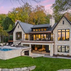 a large house with a swimming pool in the front yard and an outdoor lounge area