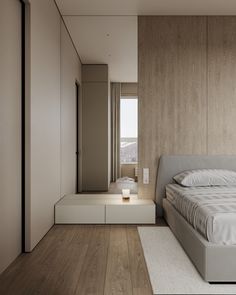 a bed sitting in the middle of a bedroom next to a wall mounted cabinet and window