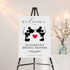 a welcome sign with two mickey mouses on it and a heart in the middle