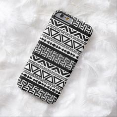 a black and white phone case with geometric designs on it, sitting on some feathers