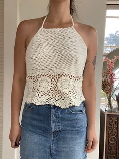 "Hand made crochet halter top in off-white  Slightly cropped  Designed and hand crocheted  Modeled on a size 6 - 34b - 28\" waist  Would best fit a size small-medium  Made from 52% cotton 48% acrylic yarn Garment Measurements  Pit to pit laying flat 16.5\" Front length 14\" Back length 8\"" Fitted Halter Top With Crochet Trim For Spring, White Crochet Lace Halter Top For Spring, White Halter Neck Crochet Top For Summer, Fitted Halter Neck Tops With Crochet Trim, Fitted Halter Neck Top With Crochet Trim, White Crochet Halter Top For Summer, Cream Halter Neck Top, White Crochet Lace Halter Top For Vacation, White Crochet Lace Crop Top