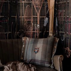 a couch with a blanket on top of it next to a wall covered in pictures