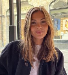 a woman standing in front of a store window