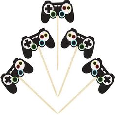 four black video game controllers on sticks in the shape of toothpicks with colored eyes