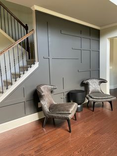 two chairs and a table in a room with wood flooring on the side wall