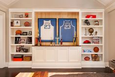 a living room filled with lots of furniture and bookshelves covered in sports memorabilia