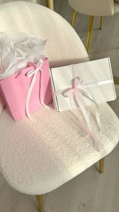 a pink gift bag sitting on top of a white chair