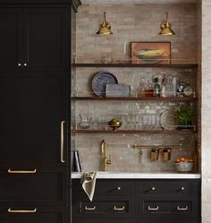 the kitchen is decorated in black and gold with brass accents, such as shelving above the sink