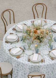 the table is set with white plates and silverware