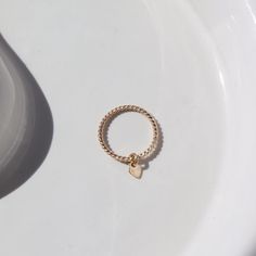 Add some love to your little one's wardrobe with our Tiny Heart Charmed Ring. This children's ring is a favorite in our Tiny Token children's collection and features a delicate 14k gold filled or sterling silver spiral band with a cute heart charm. Perfect for tiny fingers and big smiles. Make their day with this adorable keepsake ring! Our Tiny Token Collection is perfect for children ages 10 and under. Shop our Heart Charmed Ring for a ring sizes 4 and up. Not sure what size to get your little Dainty Hypoallergenic 14k Gold Filled Rings, Dainty 14k Gold Ring With Heart Charm, Hypoallergenic Dainty 14k Gold Filled Rings, Hypoallergenic 14k Yellow Gold Filled Midi Rings, Gold Dainty Heart Ring With Round Band, Dainty Hypoallergenic Heart Promise Ring, Dainty Gold Heart Ring With Round Band, Tiny Adjustable Heart Ring As Gift, Dainty Hypoallergenic Heart Ring For Promise