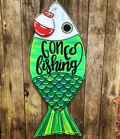 a wooden sign that says gone fishing on the side of a fence with an image of a fish