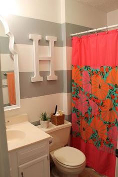 a bathroom with a shower curtain, toilet and sink