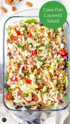 a salad in a glass casserole dish topped with lettuce and tomatoes