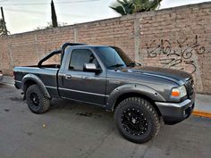 a gray truck parked next to a brick wall