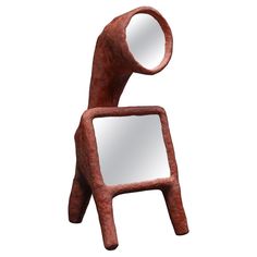 a wooden sculpture holding a mirror in it's hands