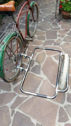 a bike with a bicycle rack attached to it on the side of a stone path